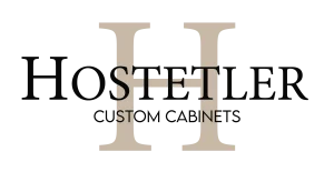 Logo featuring a prominent tan H and elegant black lettering that reads Hostetler Custom Cabinets, reflecting the craftsmanship and custom furniture expertise of Hostetler Custom Cabinetry.